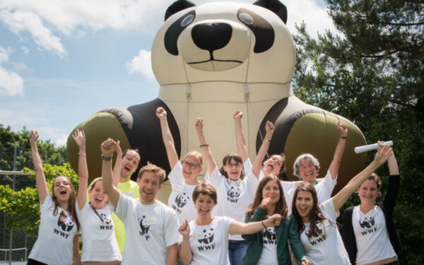 Jubelndes WWF-Team vor grossem Panda